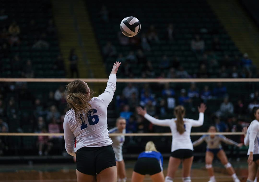 Volleyball player reaching for the ball during a match